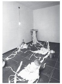 obra Instalação com camisas de força, pia, baldes, torneira, espelho, lâmpada
