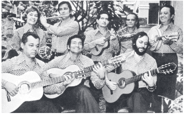A foto mostra integrantes de um grupo de choro tocando instrumentos de diferentes classificações
