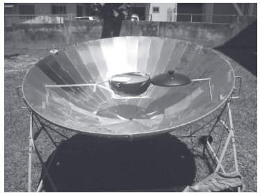 A figura mostra uma superfície refletora de formato parabólico que tem sido utilizada como um fogão solar.